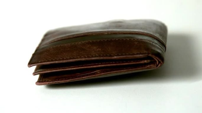 棕色皮革钱包落在白色表面上