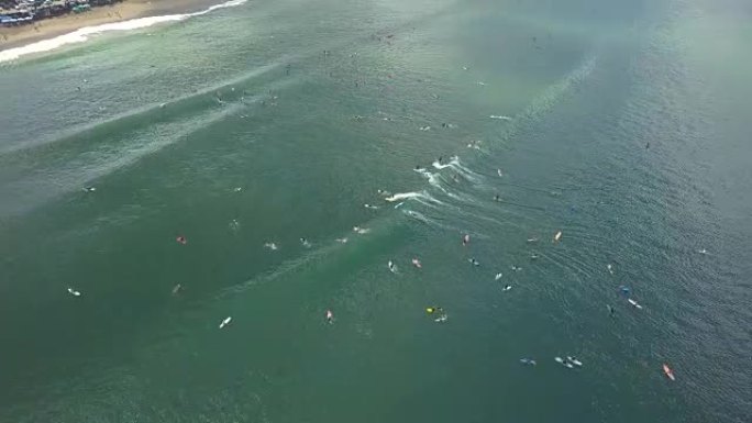 空中: 冲浪板上的人群在巴厘岛冲浪点冲浪和吸引海浪