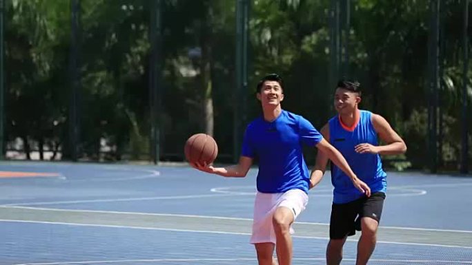 年轻的亚洲篮球运动员在室外球场上比赛