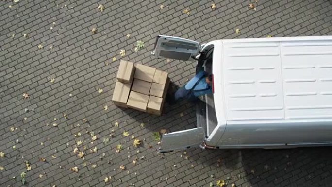 送货员用纸板箱装载他的商用货车。加速视频。