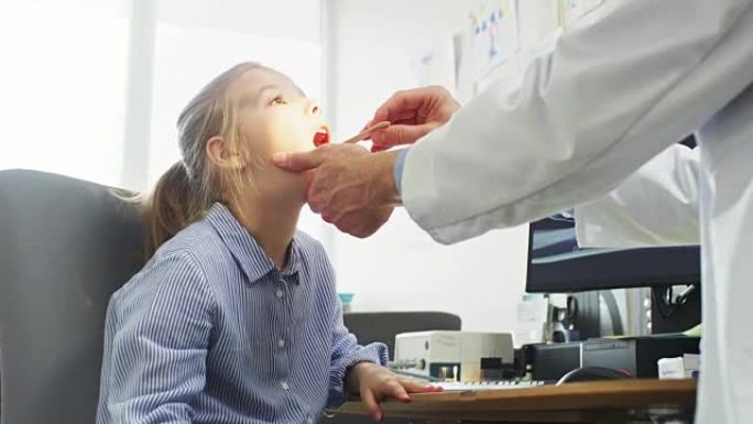 友好的医生检查小女孩的喉咙痛，治愈流感。现代医疗保健，友好的儿科医生和明亮的办公室。