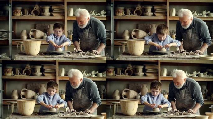 退休的祖父在舒适的家庭作坊里一起工作时，给他可爱的小孙子提供陶器基础。制作陶瓷和家庭概念。
