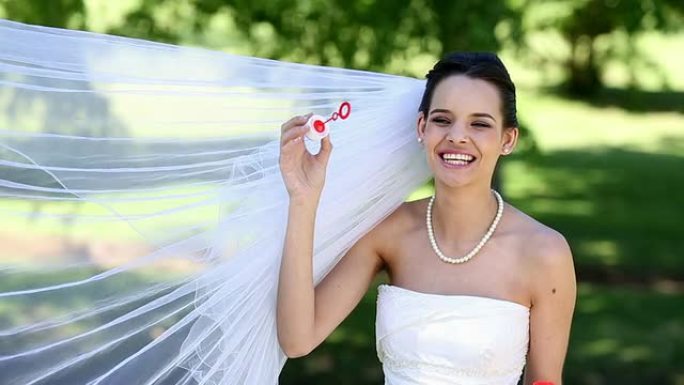 美丽的新娘在公园里吹泡泡
