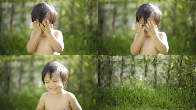 4k亚洲婴儿在户外玩偷看嘘声和微笑。