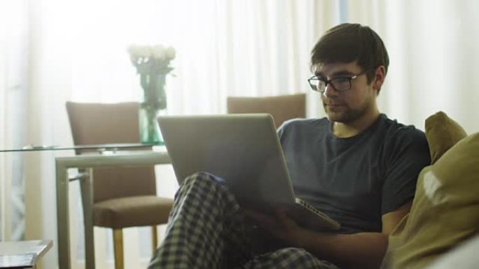 男人早上在家用笔记本电脑。在4k (UHD) 的红色电影相机上拍摄。