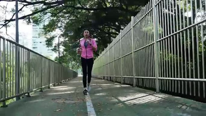 年轻的亚洲女人早上在人行道上跑步。具有复制空间的健康意识概念。健身运动人群与健康生活理念。