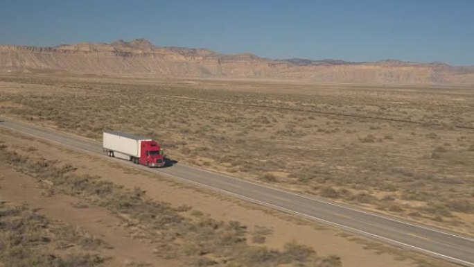 带有集装箱拖车的空中半卡车驶过犹他州广阔的沙漠