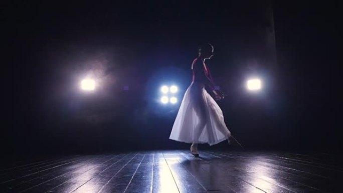 穿着飘逸长裙的孤独芭蕾舞演员在黑暗中表演。4K。