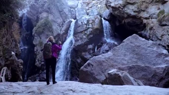 Exploring wilderness. Woman admiring mountain wate