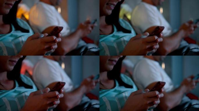 年轻夫妇在床上使用智能手机