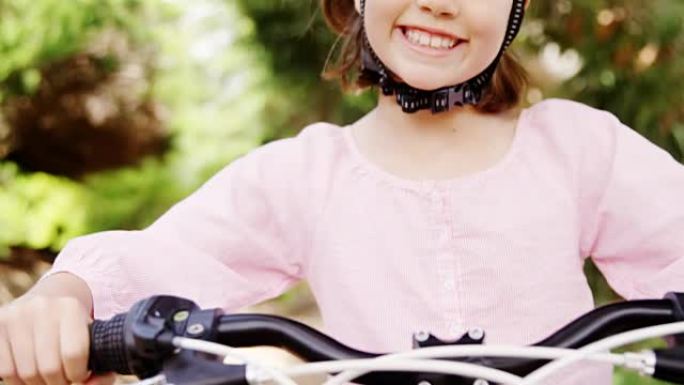 公园里站着自行车的微笑女孩的肖像