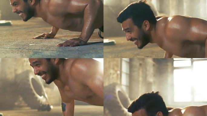肌肉裸男满身汗水在一个废弃的工厂改造成健身房做俯卧撑。这是他的健身锻炼/高强度间歇训练的一部分。