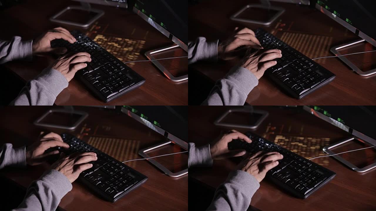 顶视图。在黑暗的房间里，男人用手在键盘上打字。黑客，it专业人员，工作中的计算机专家。无法辨认