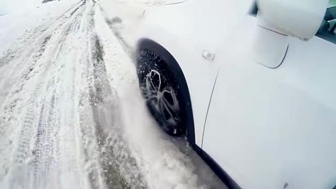 汽车车轮在冬天的雪路上打滑。4K。