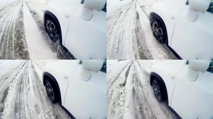 汽车车轮在冬天的雪路上打滑。4K。