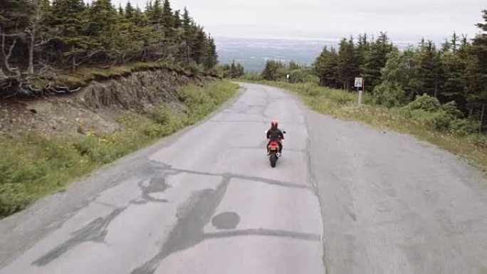 超高清4K天线:一个骑摩托车的人在乡村公路上兜风