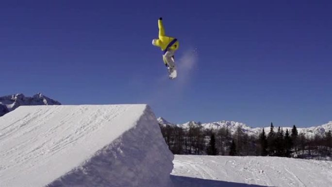 慢动作: 滑雪者在雪公园跳过踢脚