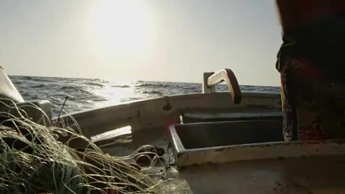 渔夫女士在阳光明媚的渔船上移动水桶