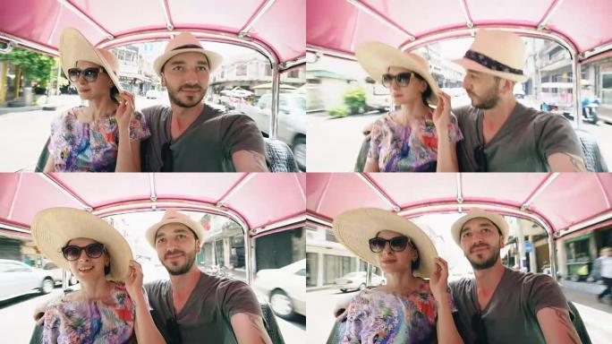 年轻英俊的男人和他的女朋友骑着传统的泰国公共汽车松托。夫妻在蜜月期间旅行泰国