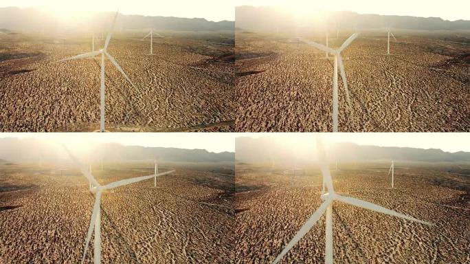 日落时在沙漠中转弯的风车的鸟瞰图