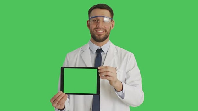 一位英俊的科学家戴着防护眼镜，手持绿色屏幕的平板电脑。背景是绿色屏幕。