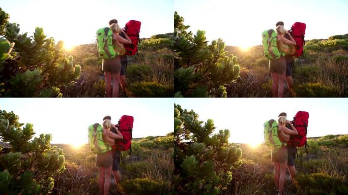 徒步旅行后景情侣拥抱，在大自然中观赏日出
