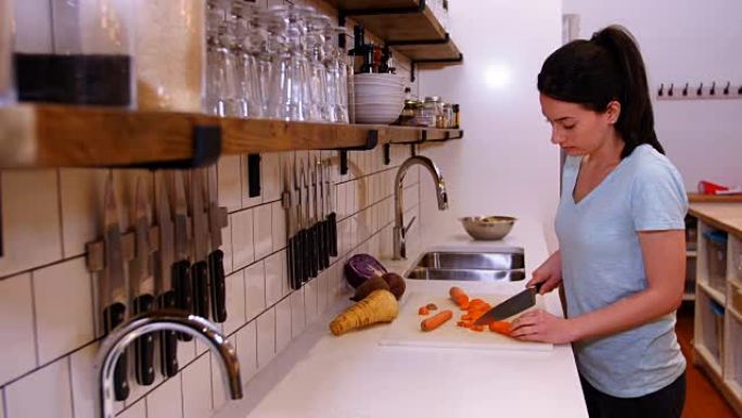 女人在厨房柜台切胡萝卜