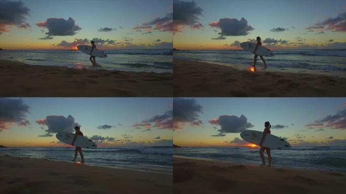 冲浪女子日落后在沙滩上散步