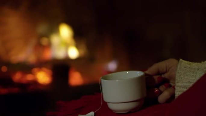 4k特写女人放松，在舒适的壁炉旁喝茶，慢动作