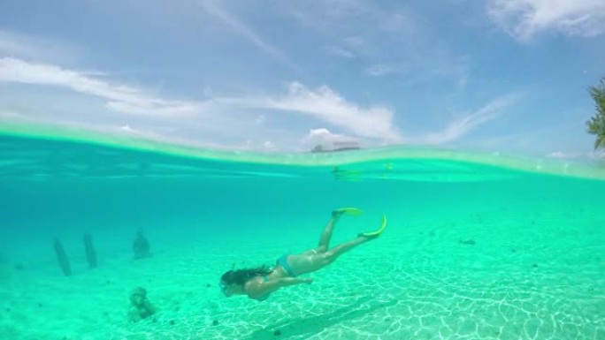 女人在梦幻般的波拉波拉岛前水下潜水