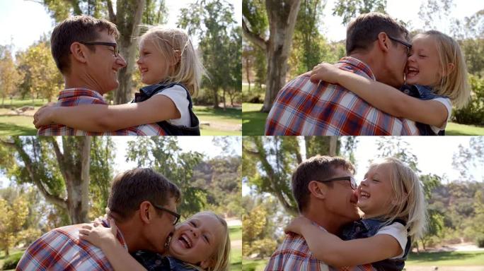 爸爸和小女儿在公园里互相拉脸