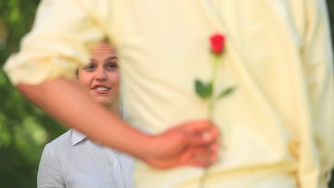 男人向他漂亮的女朋友献上一朵玫瑰