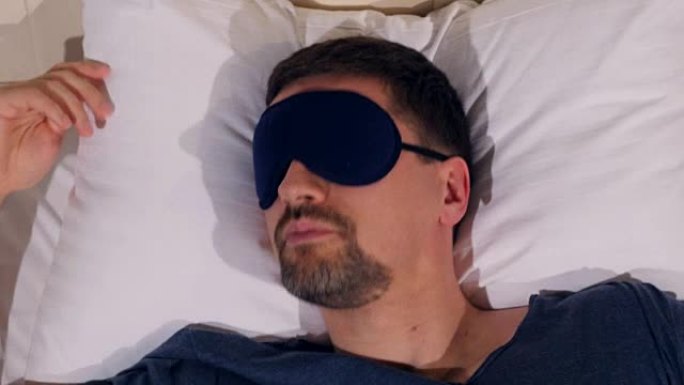 戴着睡眠面具的男人患有失眠的肖像。4K。