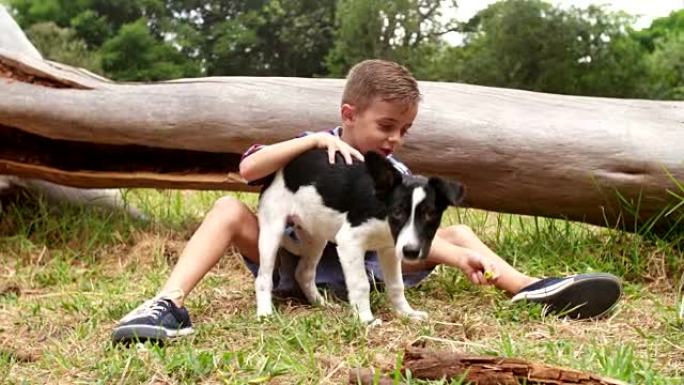 快乐男孩和他的小狗在草地上嬉戏