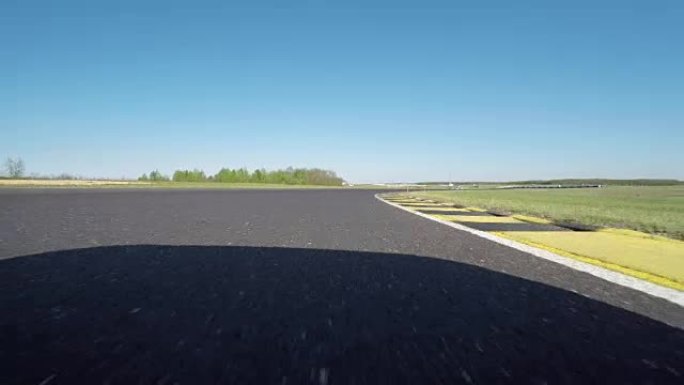 FPV低角度: 赛车在阳光明媚的日子在赛道上快速行驶
