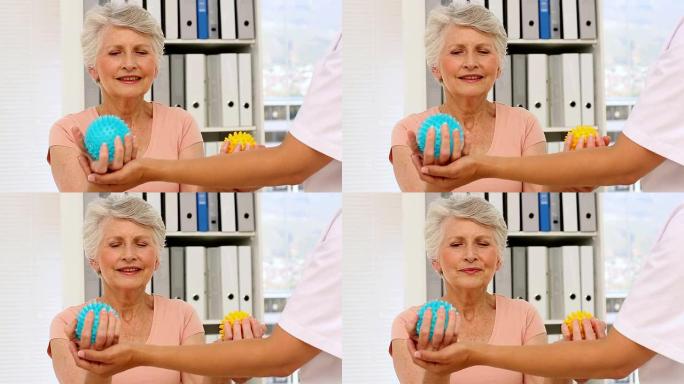 护士向老年患者展示如何使用按摩球