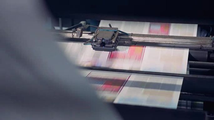 未切割的印刷纸张正在由工业设备处理，并沿其向上移动
