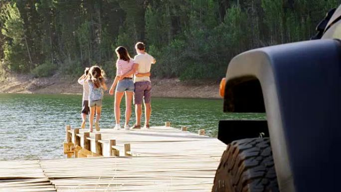 孩子们与父母一起欣赏码头上的湖畔景观