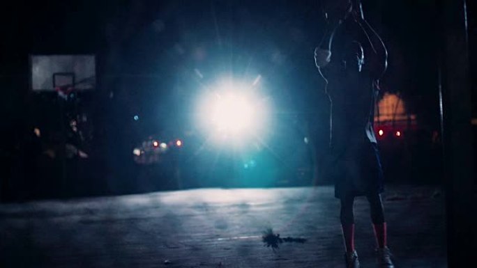 篮球运动员晚上独自在球场上练习