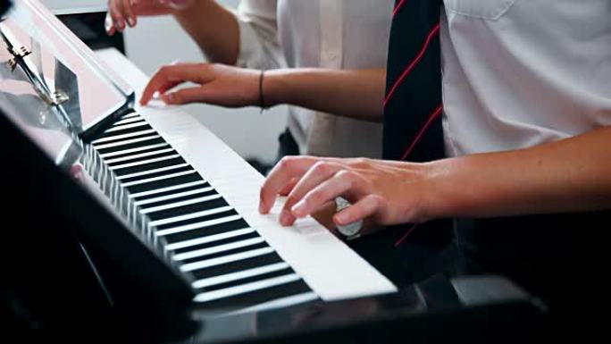 女学生与老师在音乐课上弹钢琴