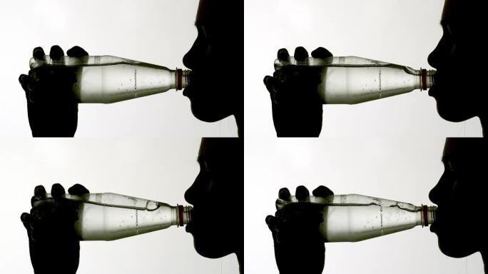 从瓶子里喝水的女人的剪影