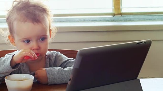 婴儿在吃早餐时使用数字平板电脑4k
