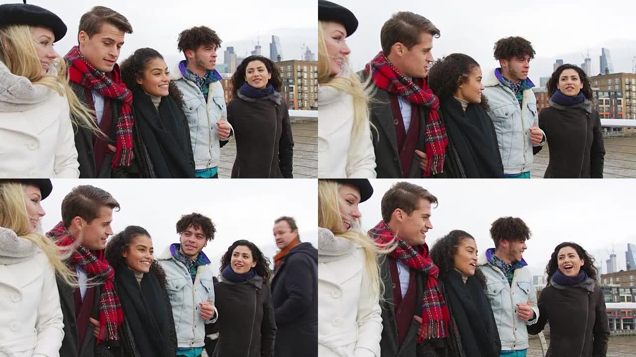 一群年轻的朋友走过伦敦的千年桥
