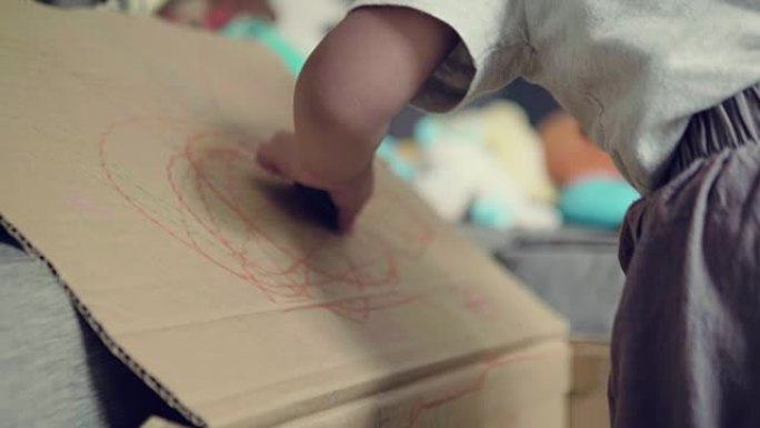 亚洲男婴在纸板上素描和绘画
