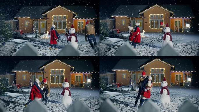 在快乐的冬天晚上，年轻的父亲，母亲和可爱的小女儿在雪球中玩耍，在他们用花环装饰的田园诗般的房子的后院
