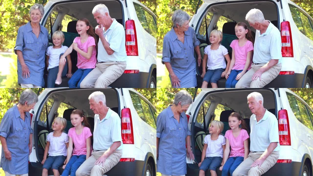 快乐的家庭坐在汽车后备箱上