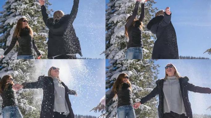 两个女人在雪地里跳舞和玩耍，像下雪一样向空中扔雪