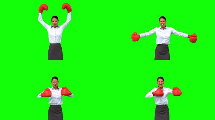 坚定的女商人在绿色屏幕上打着拳击手套打手势