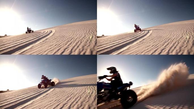 四轮赛车手驾驶着阳光耀斑的沙丘