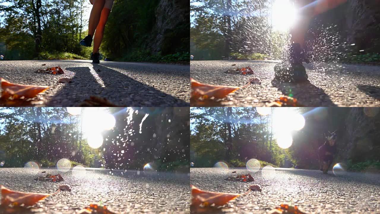 慢动作，镜头耀斑: 湿徒步运动鞋撞到沥青时，水会飞溅。